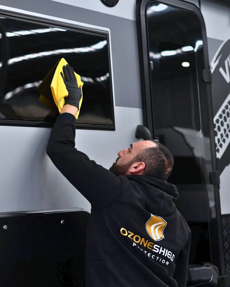 Technician wiping a coated caravan window